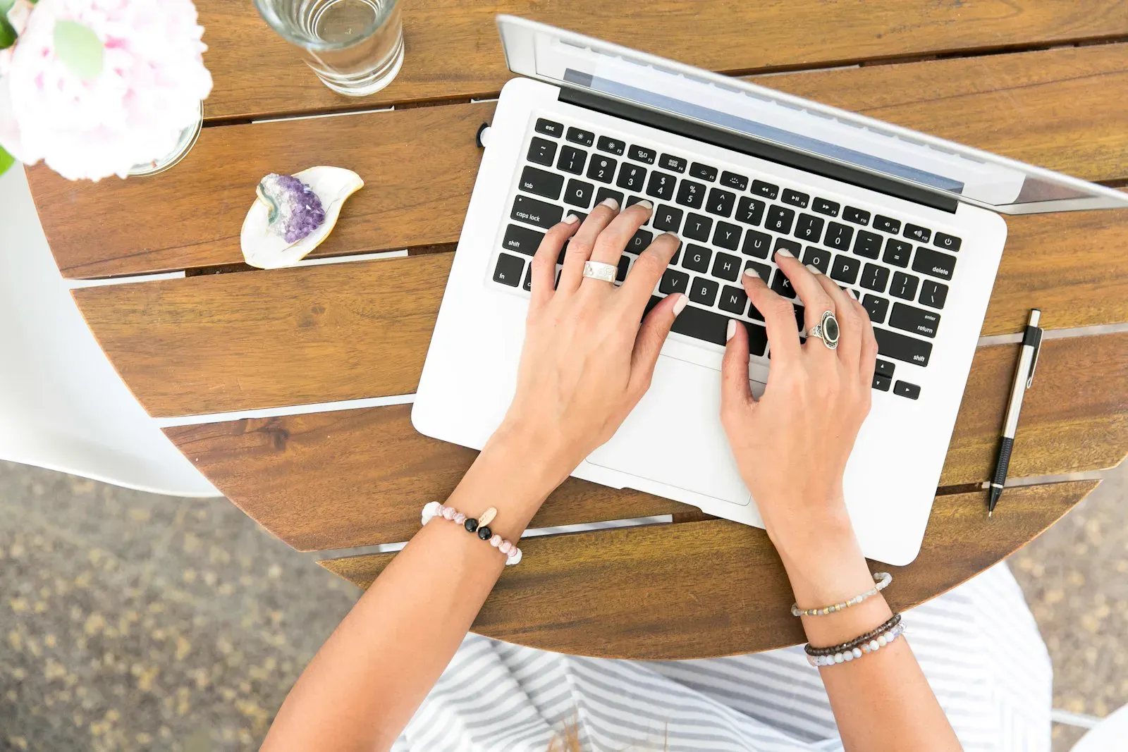 An open MacBook on a clean wooden desk during a focused writing session.
