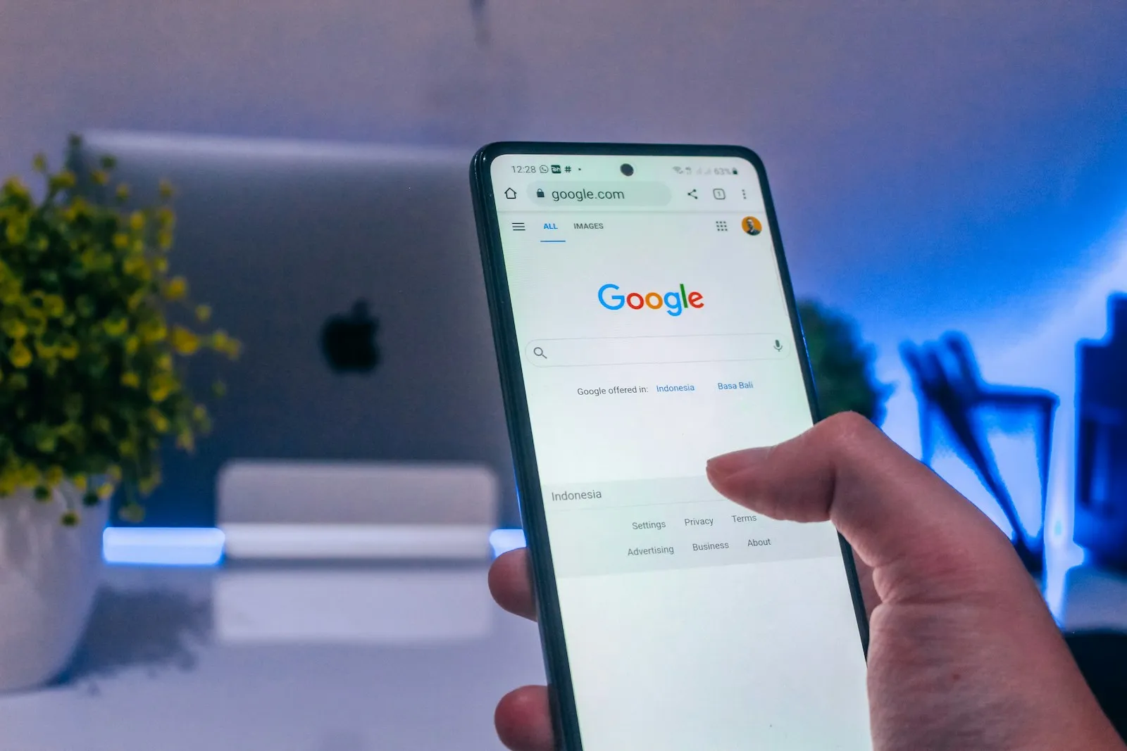 A hand holding a smartphone displaying a social media feed, the surface where Meta ads compete for scrolling attention.