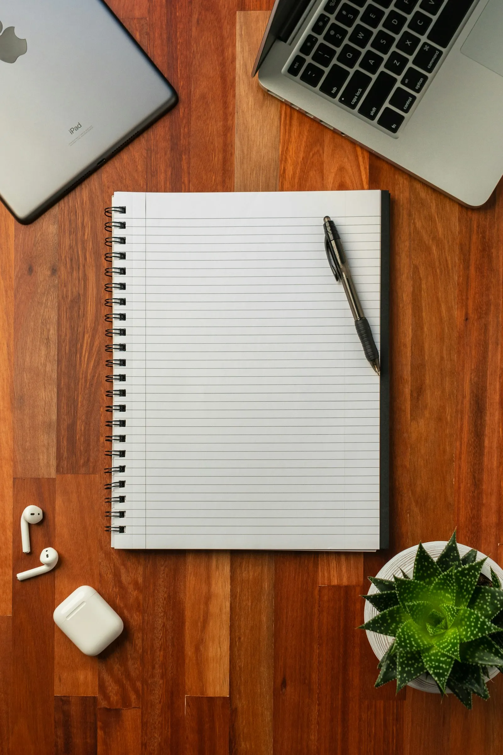 A black pen resting on an open white notebook, representing the early-stage planning work that has to happen before any new business spends a dollar on ads.