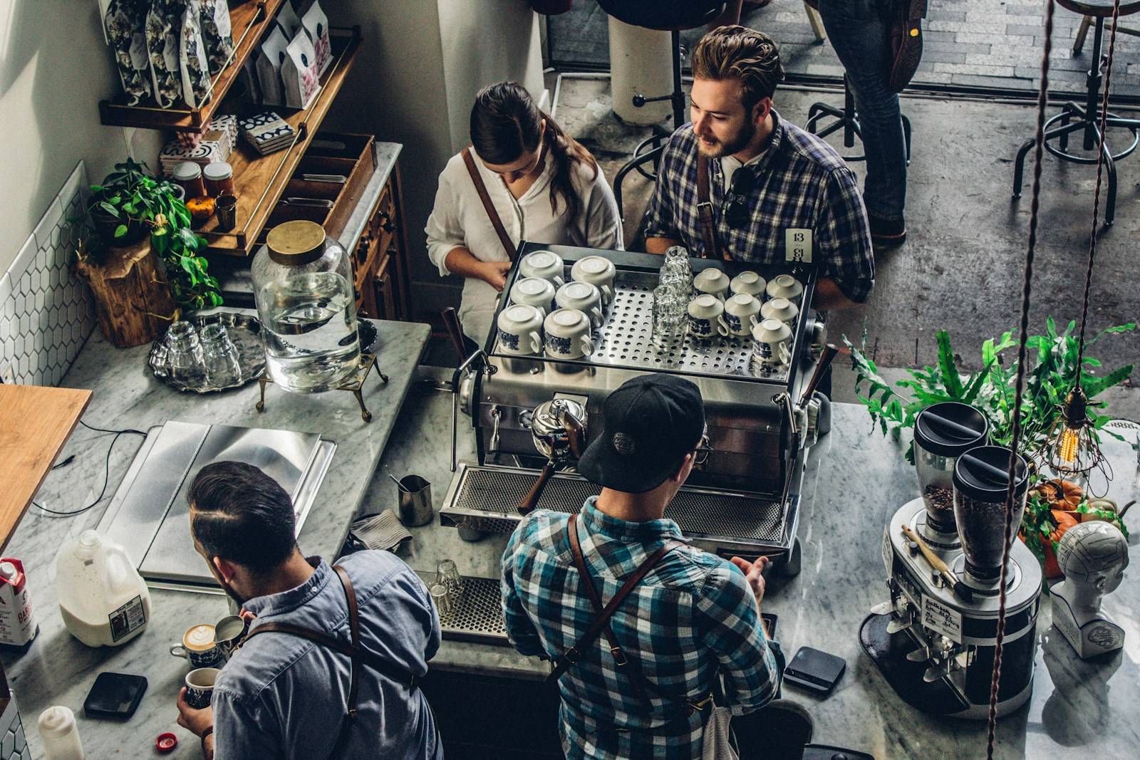 Customer being served at a busy coffee shop counter, a typical small business in action.